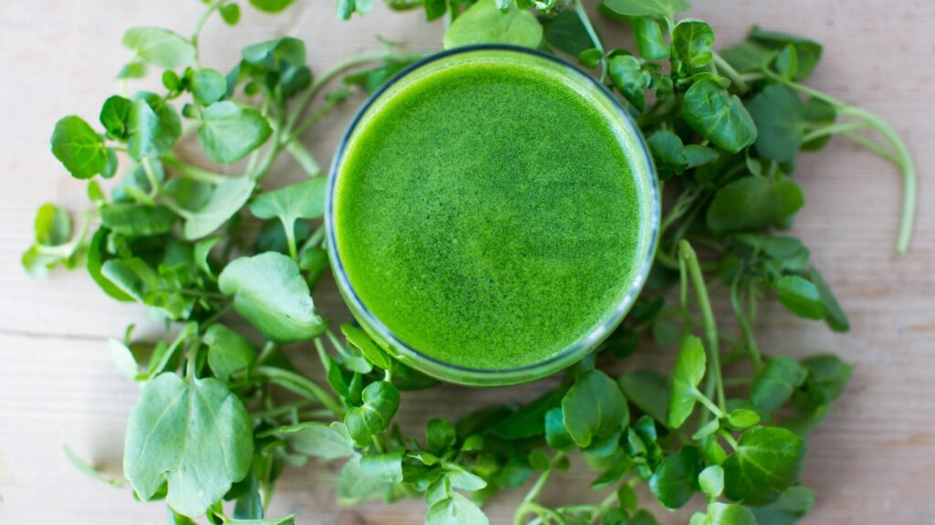 صورة لورق الجرجير الطازج على طاولة خشبية مع خلفية داكنة – يُظهر العناصر الطبيعية الغنية في النبات الأخضر المفيد للصحة.